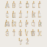 Collection of gold alphabet pendants, each adorned with sparkling gemstones, displayed on a light beige background.